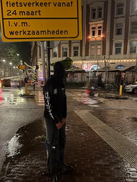 Night street shot in the rain wearing the Essentials Thermal